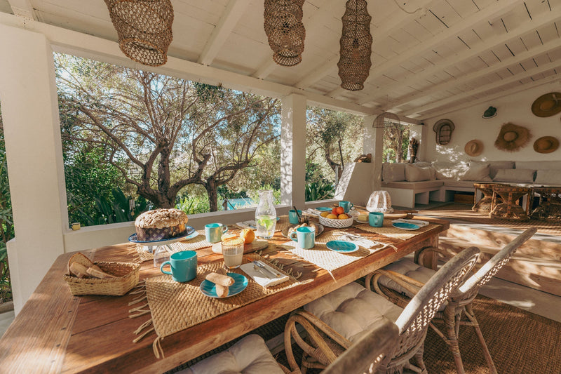 Breakfast table laid on a shaded terrace at Il Polpo Nero villa in Sardinia, illustrating dining on your own schedule with no fixed hours.