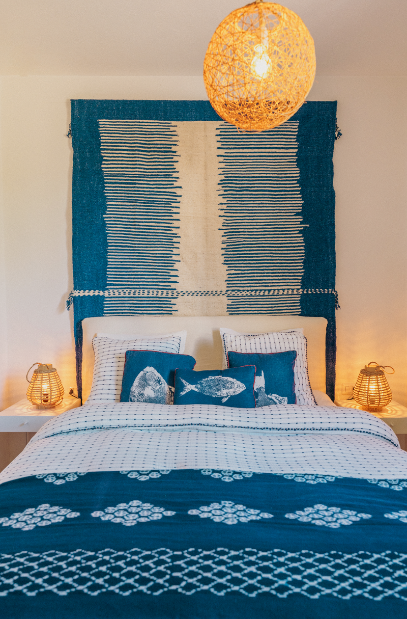 Bedroom with blue and white patterned bedding and headboard.