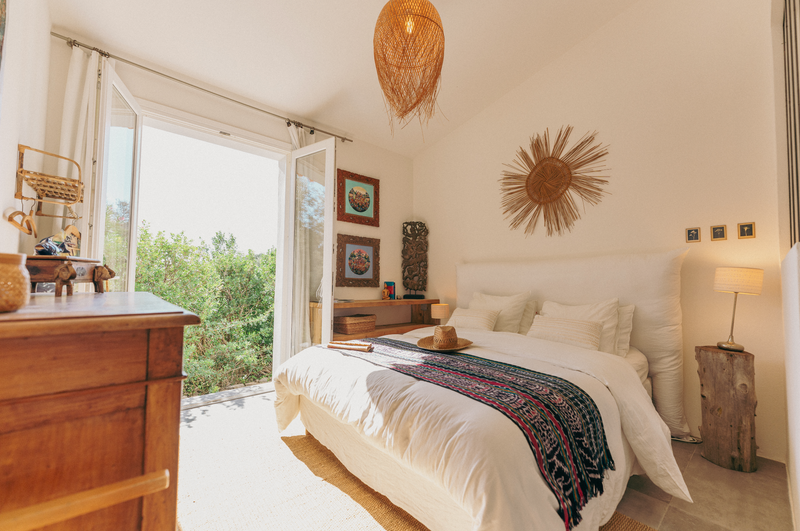 Cozy bedroom with a bed, wooden dresser, and decorative elements.