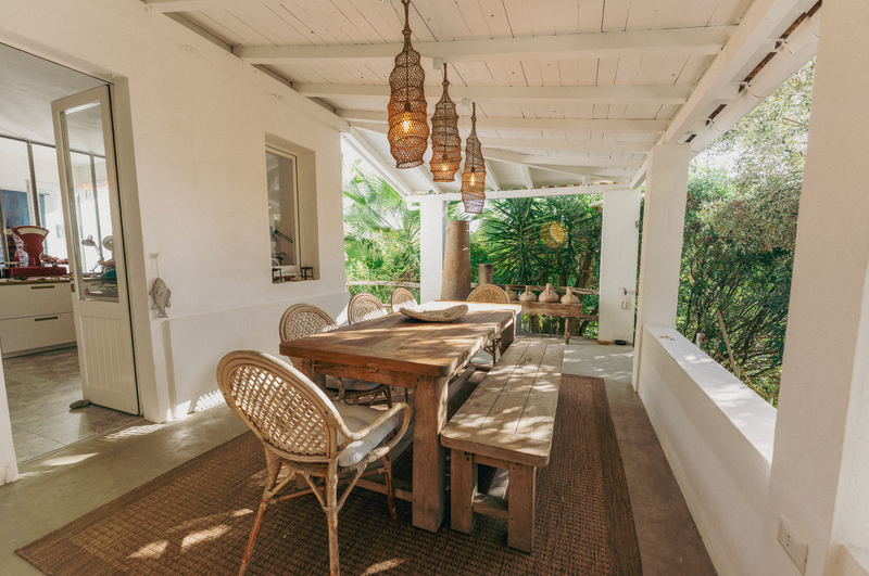 Outdoor dining area with wooden table and chairs on a patio