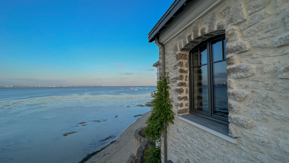 Ker Gonan's stone facade and picture window looking over the beach at Le Pouliguen