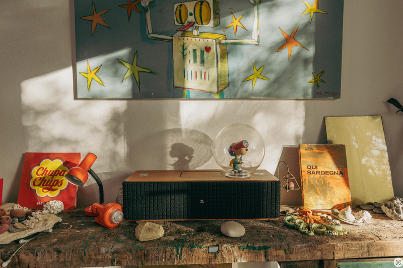 Vintage-style room with a shelf displaying various items including a Chupa Chups pack and a framed artwork.