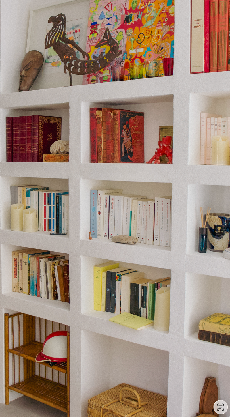 White bookshelf with various books and decorative items
