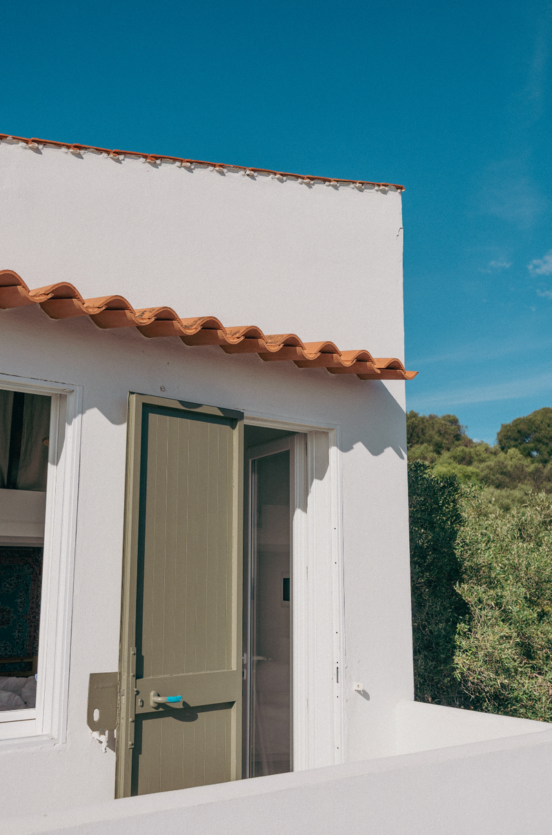 White building with an open door and a clear blue sky
